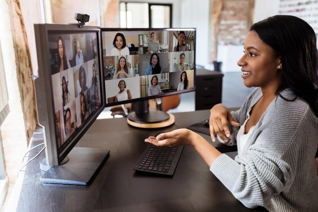 One person at their desk speaking to several others in a teleconference meeting.