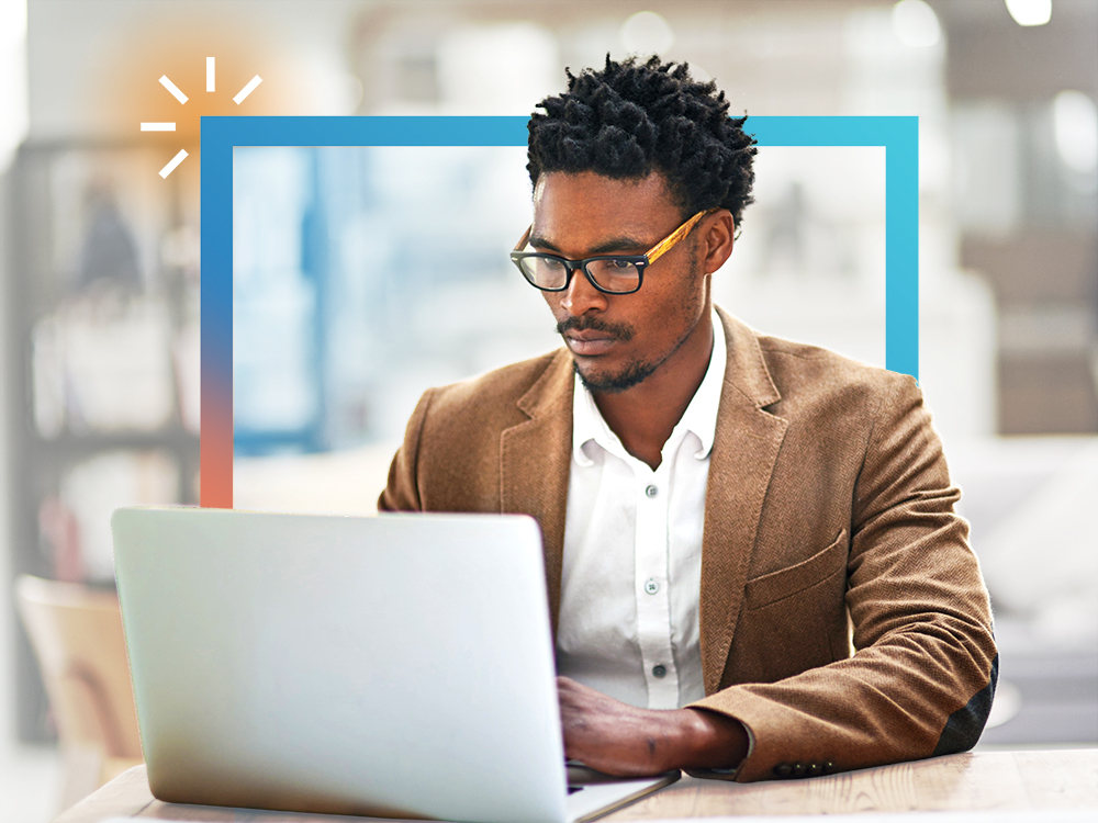 Individual in a brown blazer working on a laptop, with a blue-orange frame.