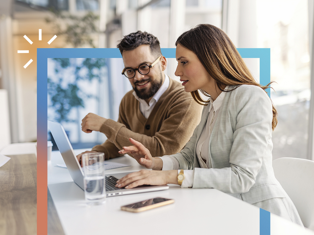 Professionals collaborating on laptops in an office setting with blue accents.