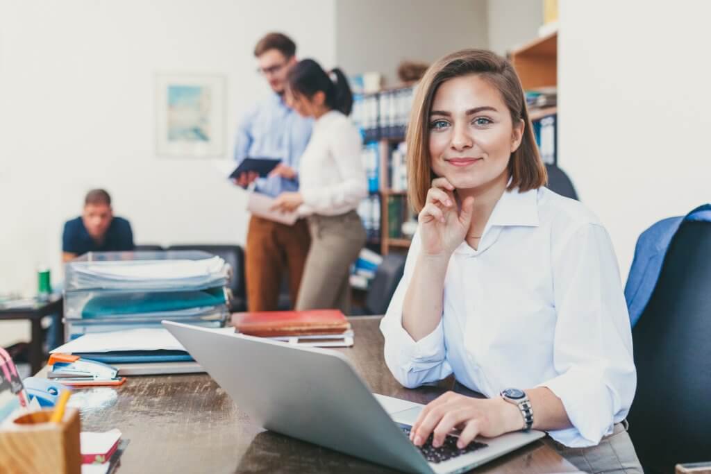 Women in white shirt in office setting.