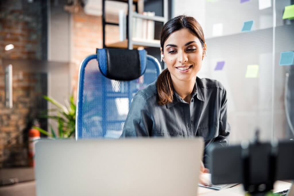 Woman at a computer in an office setting.